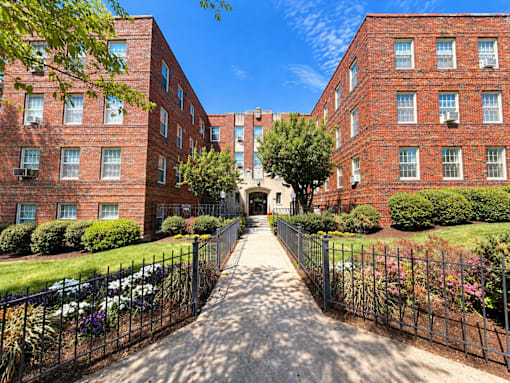 A long, narrow alleyway between two red brick apartment buildings.