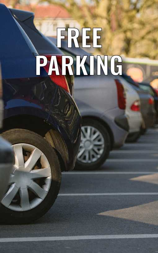 A line of cars parked in a parking lot with the words "FREE PARKING" superimposed on the image.
