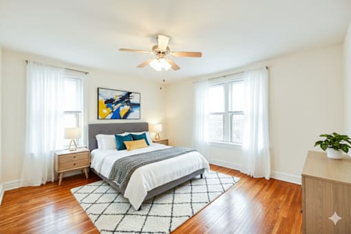 A bedroom with a bed, nightstands, and a ceiling fan.