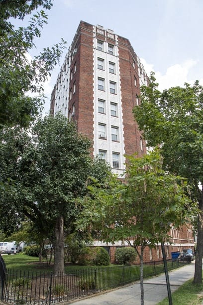 a tall brick building with trees in front of it