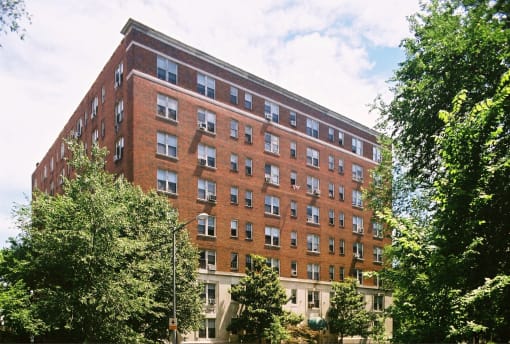 a tall brick building with trees in front of it