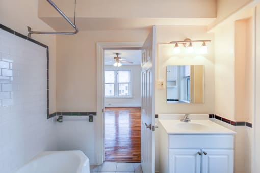bathroom with tub, vanity, and view of bedroom at hampton courts apartments in washington dc
