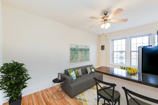 a living room with a couch and a table and a ceiling fan