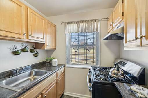 A kitchen with wooden cabinets and a black stove top oven.