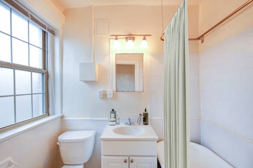 A white bathroom with a toilet, sink, and bathtub.