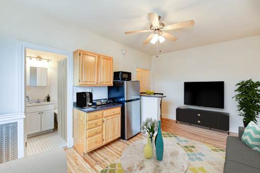 A kitchen with wooden cabinets and a black fridge.