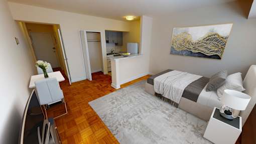 A bedroom with a bed, chair, and painting on the wall.