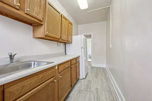 A kitchen with wooden cabinets and a white sink.