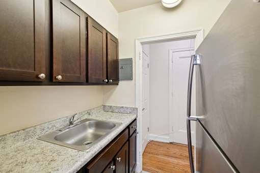 A kitchen with a sink and a refrigerator.
