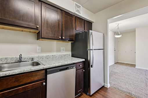 A kitchen with a black refrigerator and a white refrigerator freezer.