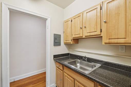 A kitchen with wooden cabinets and a granite countertop.