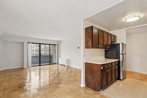 A kitchen with wooden cabinets and a refrigerator.