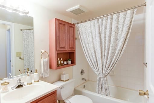 A white bathroom with a white tub and a white shower curtain.