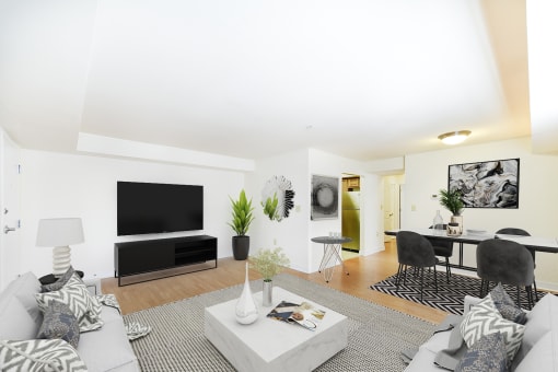 living area with sofa, coffee table, dining area, tv, and hardwood flooring at jasper place apartments in washington dc