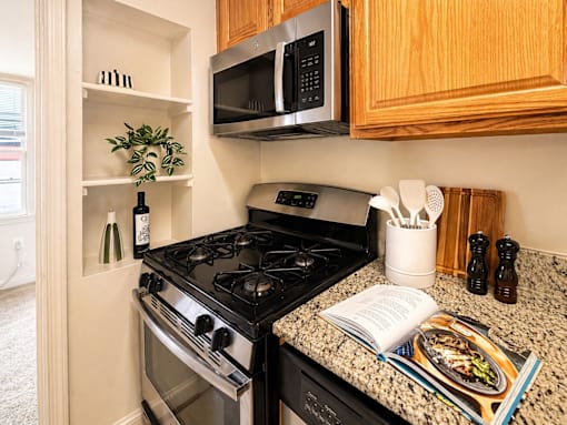 A kitchen with a black stove and a black microwave above it.