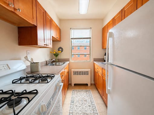A kitchen with a white gas stove and a white refrigerator.