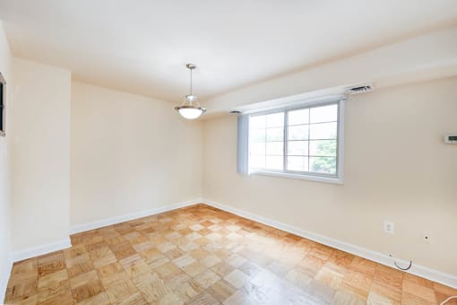 vacant dining area with lighting, wood floors and large window at naylor overlook apartments in skyland washington dc
