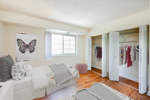 bedroom with two full sized beds, hardwood flooring, window and large closets at naylor overlook apartments in washington dc