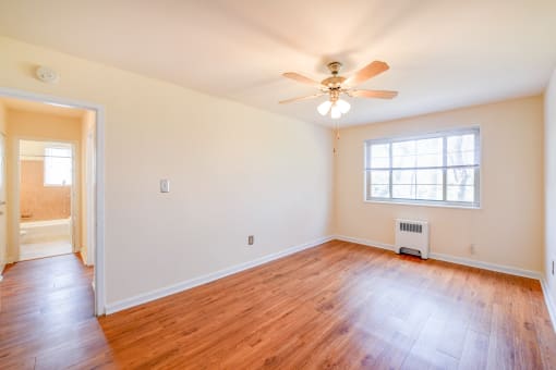 vacant bedroom with hardwood flooring and ceiling fan at new horizon apartments in washington dc