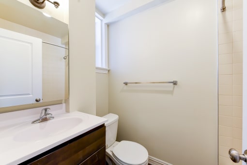 bathroom with sink, toilet, tub and large mirror at petworth station apartments in washington dc