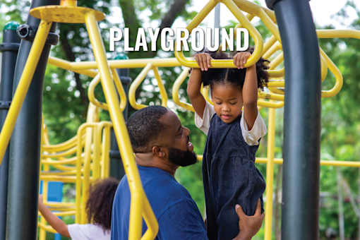 A child is climbing on a playground structure with the word "PLAYGROUND" written on it.