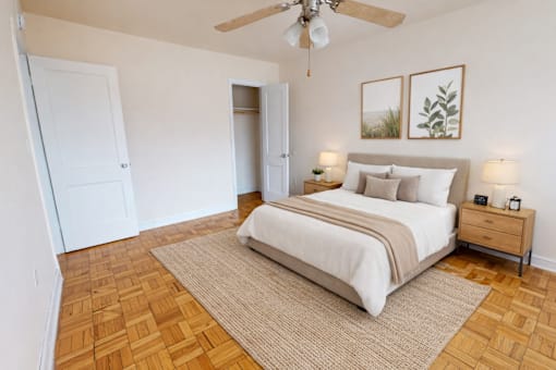 A bedroom with a bed, nightstand, and two framed pictures on the wall.