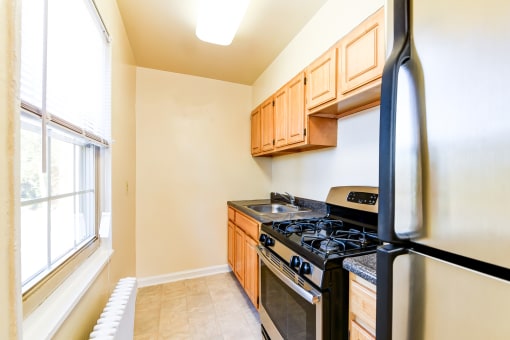 kitchen with stainless steel appliances and wood cabinetry at richman apartments in washington dc