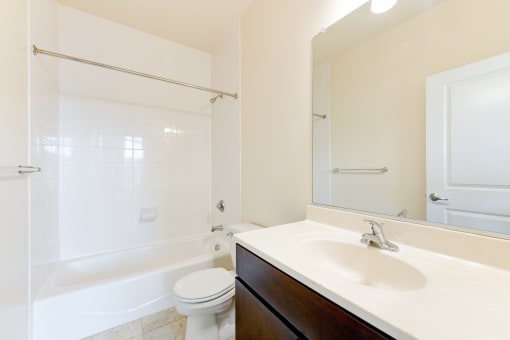 bathroom with tub, sink, toilet, and large mirror at sheridan station south townhomes in washington dc