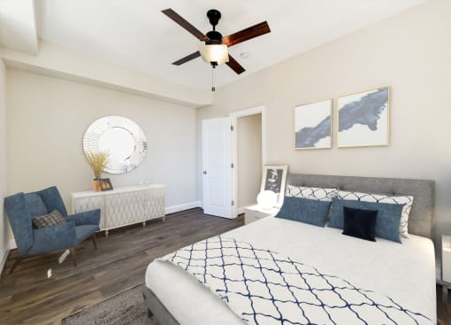 bedroom with bed, nightstand, dresser, sitting area and ceiling fan at petworth station apartments in washington dc
