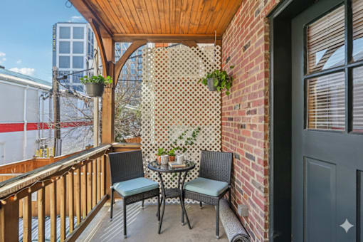 A small balcony with a table and chairs.