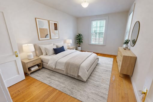 A bedroom with a bed, nightstands, and a rug.