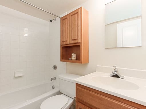 bathroom with tub, toilet, medicine cabinet, mirror and sink at t street apartments in washington dc