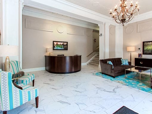 a lobby with a desk, chairs and a chandelier at the calverton apartment building in adams morgan washington dc