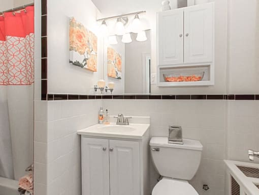 a bathroom with a sink, toilet and mirror at the calverton apartments in washington dc
