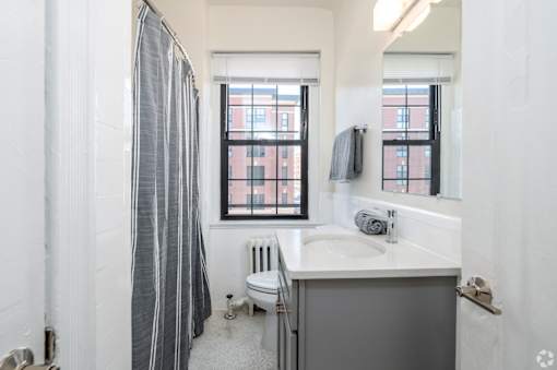 A bathroom with a toilet, sink, and shower.