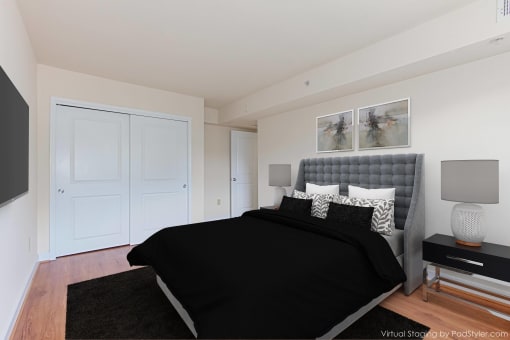 bedroom with bed, nightstand, large closet and wood floors at t street apartments in washington dc
