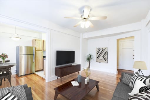 living area with sofa, coffee table, credenza, tv, hardwood floors, ceiling fan and view of kitchen at wakefield apartments in washington dc