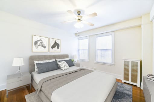bedroom with bed, nightstands, hardwood floors, ceiling fan and large windows at wakefield hall apartments in washington dc