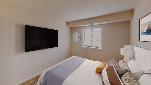Bedroom with dresser, tv, bed and large windows at washington view apartments in southeast dc