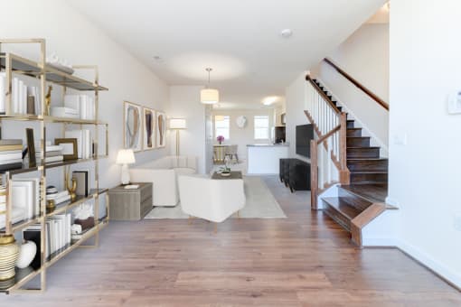 view of large living area with sofa, sitting area, bookshelves and staircase at sheridan station south townhomes in washington dc