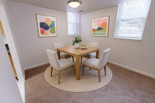 A dining room with a round table and chairs.
