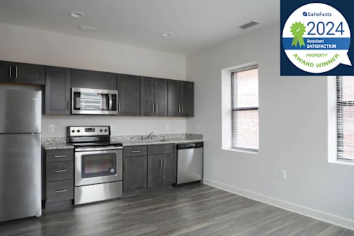 A modern kitchen with stainless steel appliances and a blue award sign for 2024 residential satisfaction award winner.