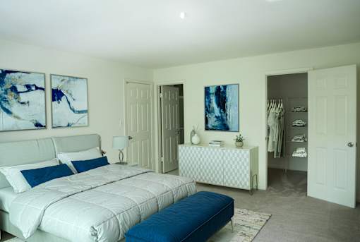 A bedroom with a large bed and a dresser with a mirror.