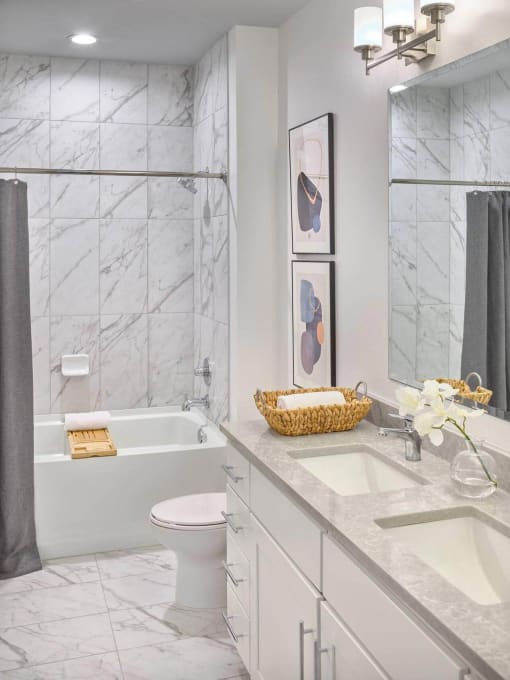 a white bathroom with a toilet and a tub and a sink at The Encore at Ingram Manor, Pikesville, MD, 21208