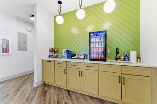 A kitchen with a green wall and wooden cabinets.