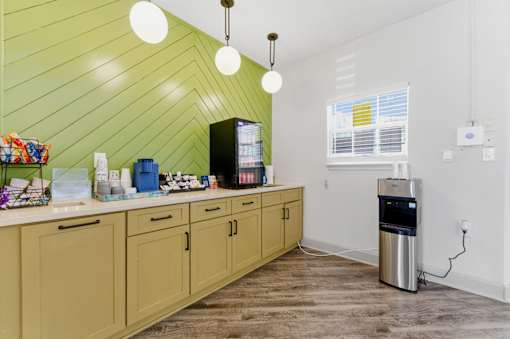 A kitchen with wooden cabinets and a green wall.