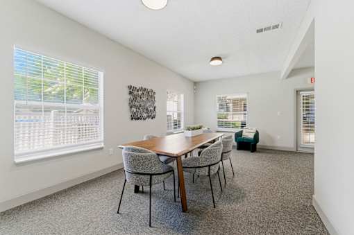 A dining room with a wooden table and chairs.