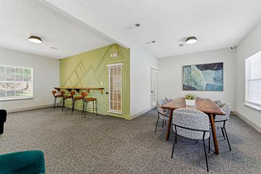 A room with a dining table and chairs.