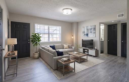 A modern living room with a grey sofa set and a wooden coffee table.