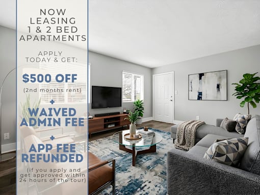 A living room with a sign offering $500 off for leasing 1 & 2 bed apartments.